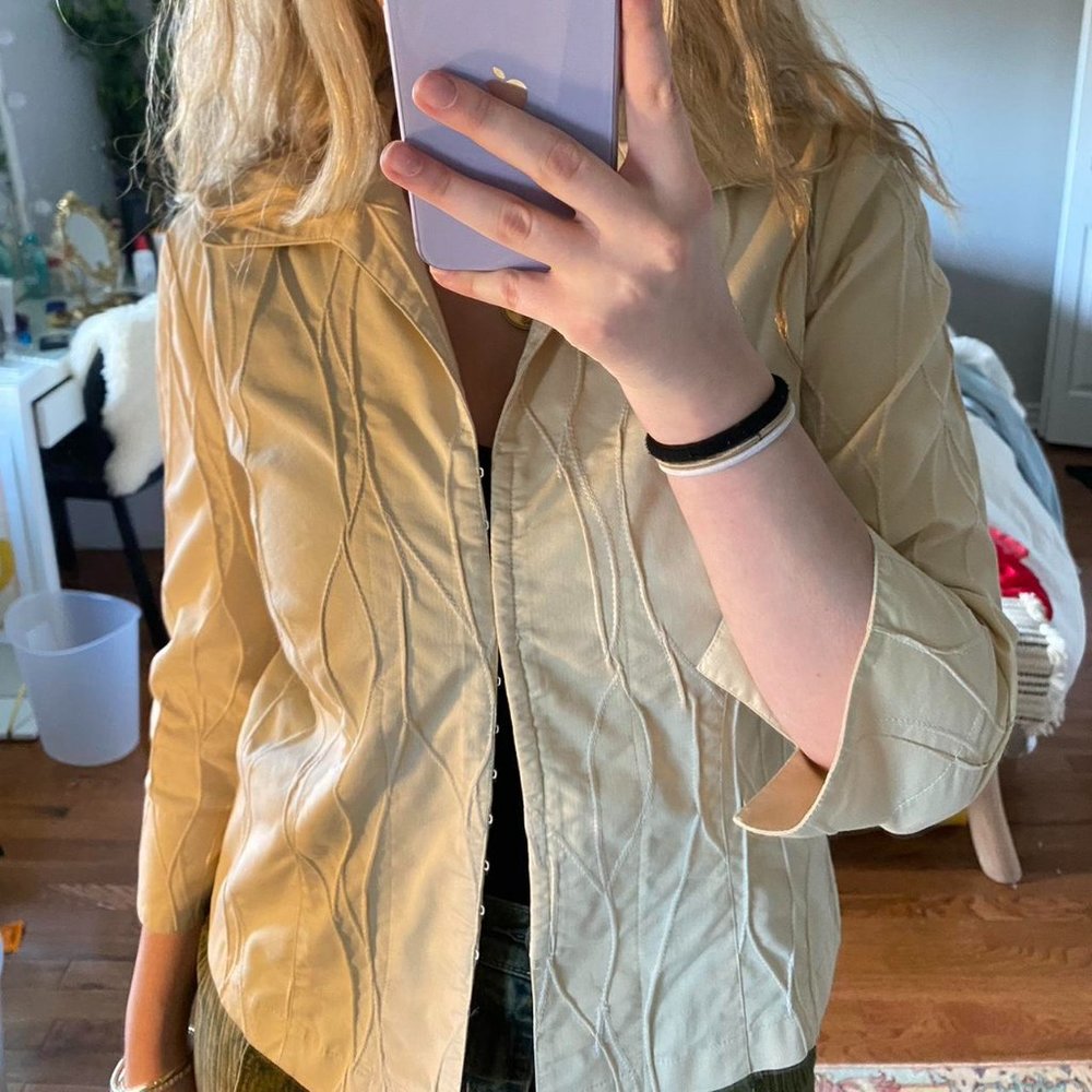 Beige shirt with clasps all up and down the front of the top